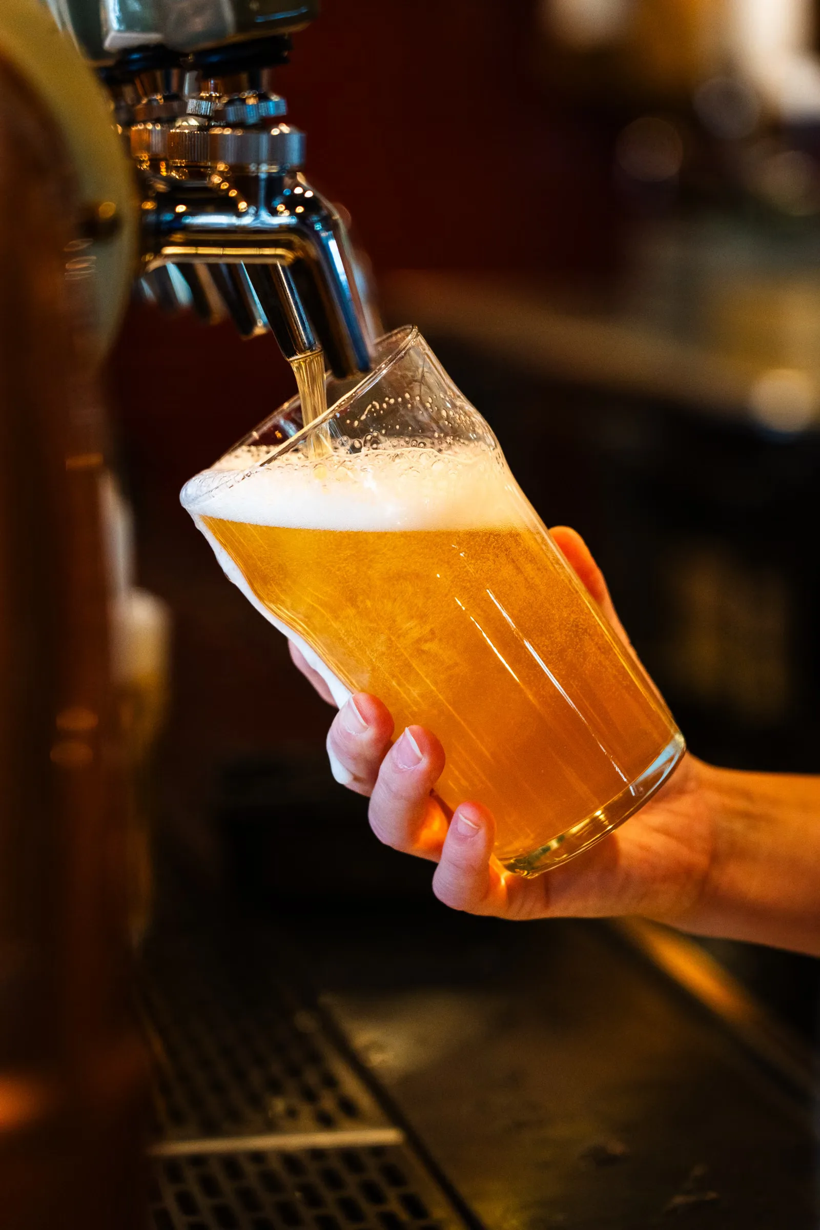 Gros plan sur une bière pression versée dans un verre à pintes dans un bar à Montréal, Canada.