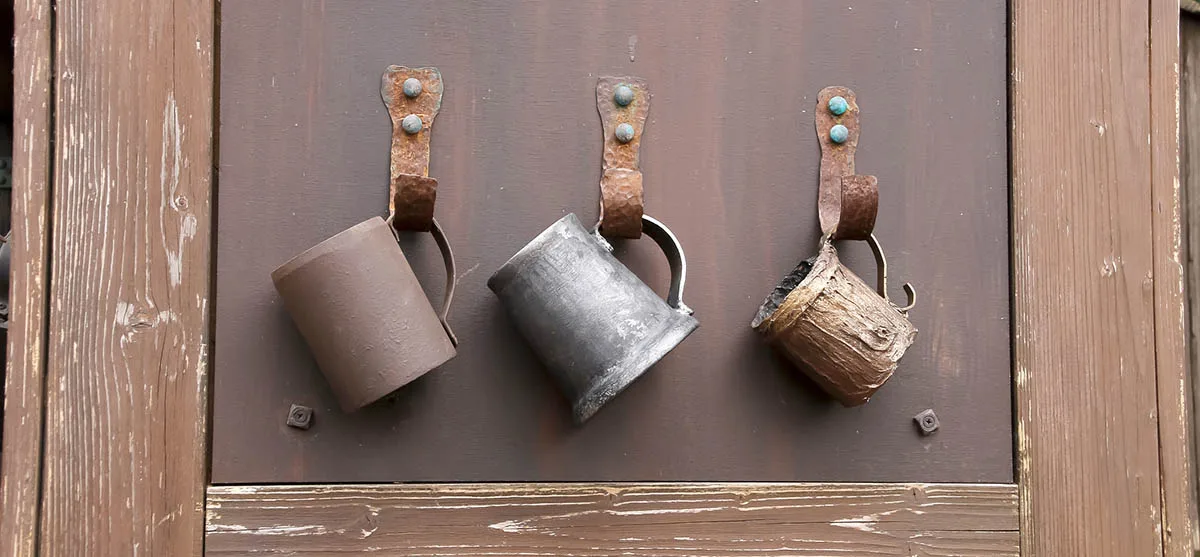 Trois gobelet de bière anciens accrochés sur un mur