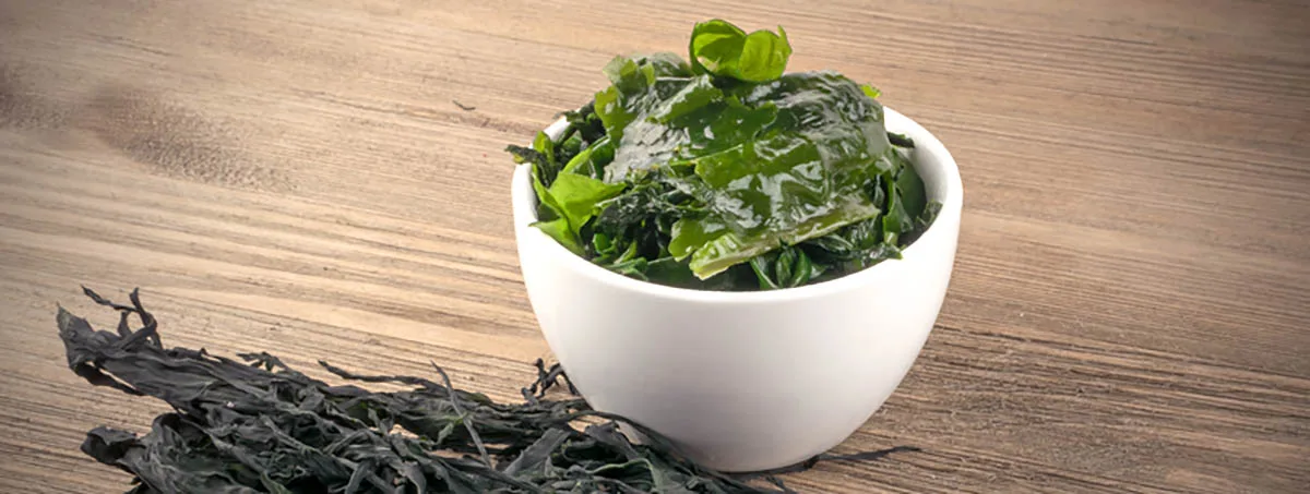 Tas d'algues sèches Wakame sur fond en bois. Nourriture saine aux algues