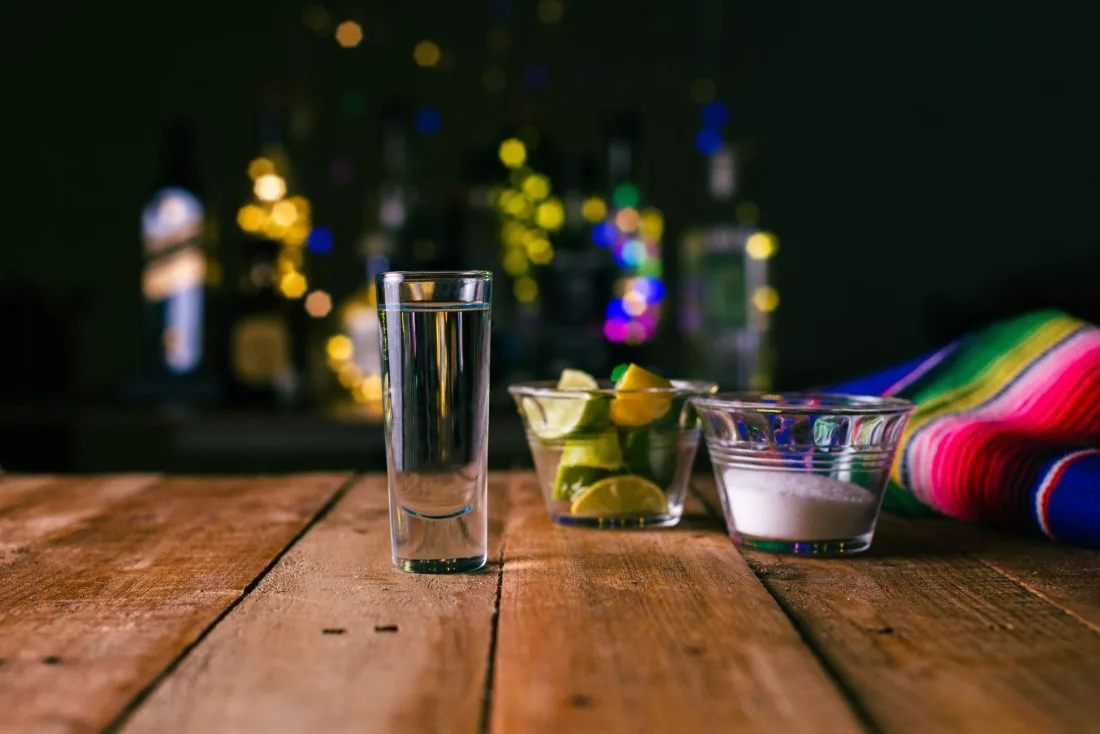 Shot of tequila on a wooden table.