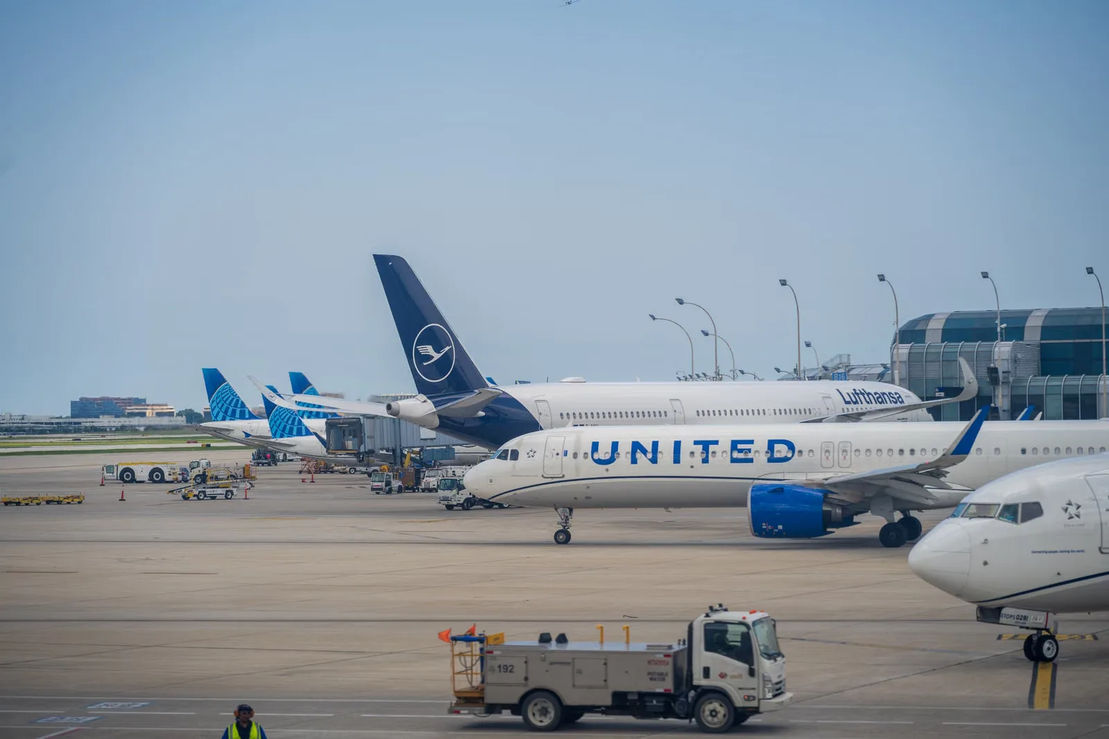Vue de divers avions le long d'un terminal et d'une piste d'aéroport très fréquentés.