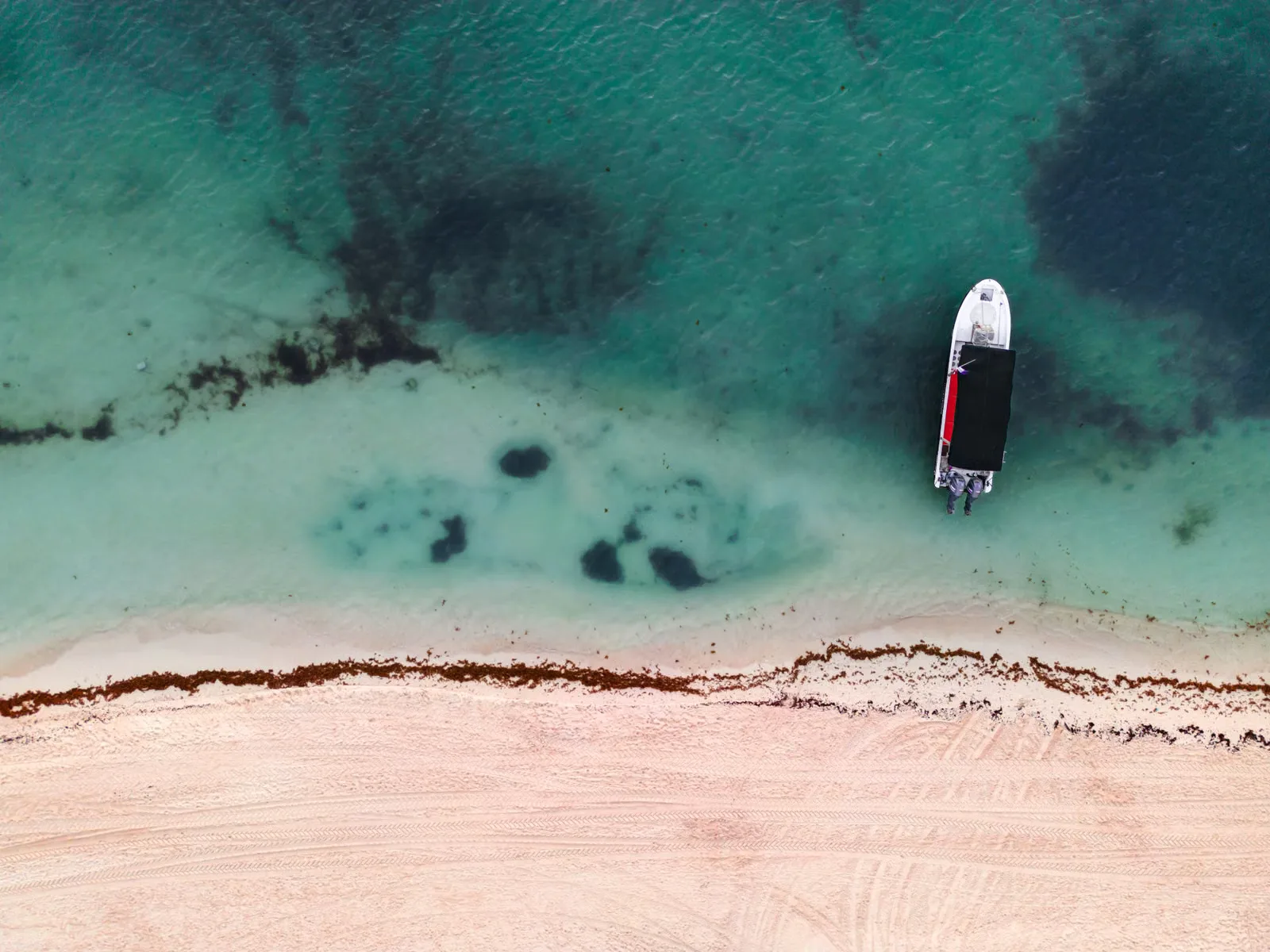 Une vue aérienne sereine d'un bateau au bord de la plage à Playa del Carmen, Mexique.