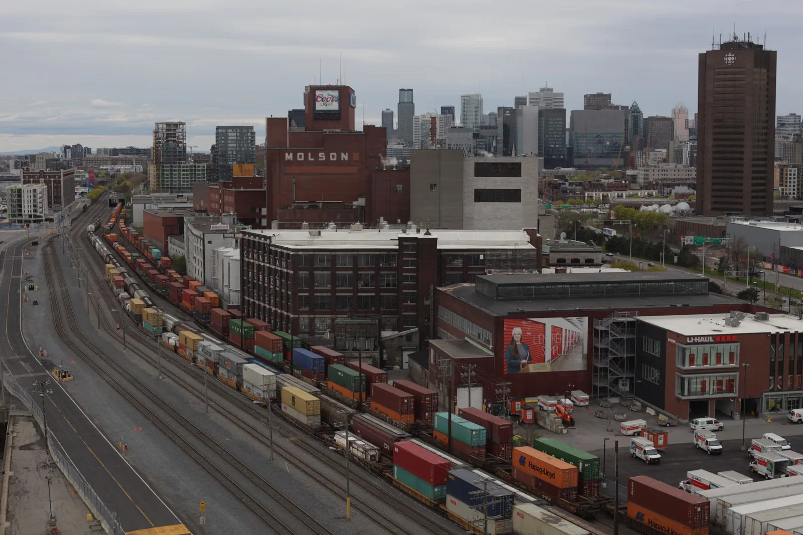 Vue aérienne des voies ferrées et de l'édifice Molson dans le paysage urbain du centre-ville de Montréal.