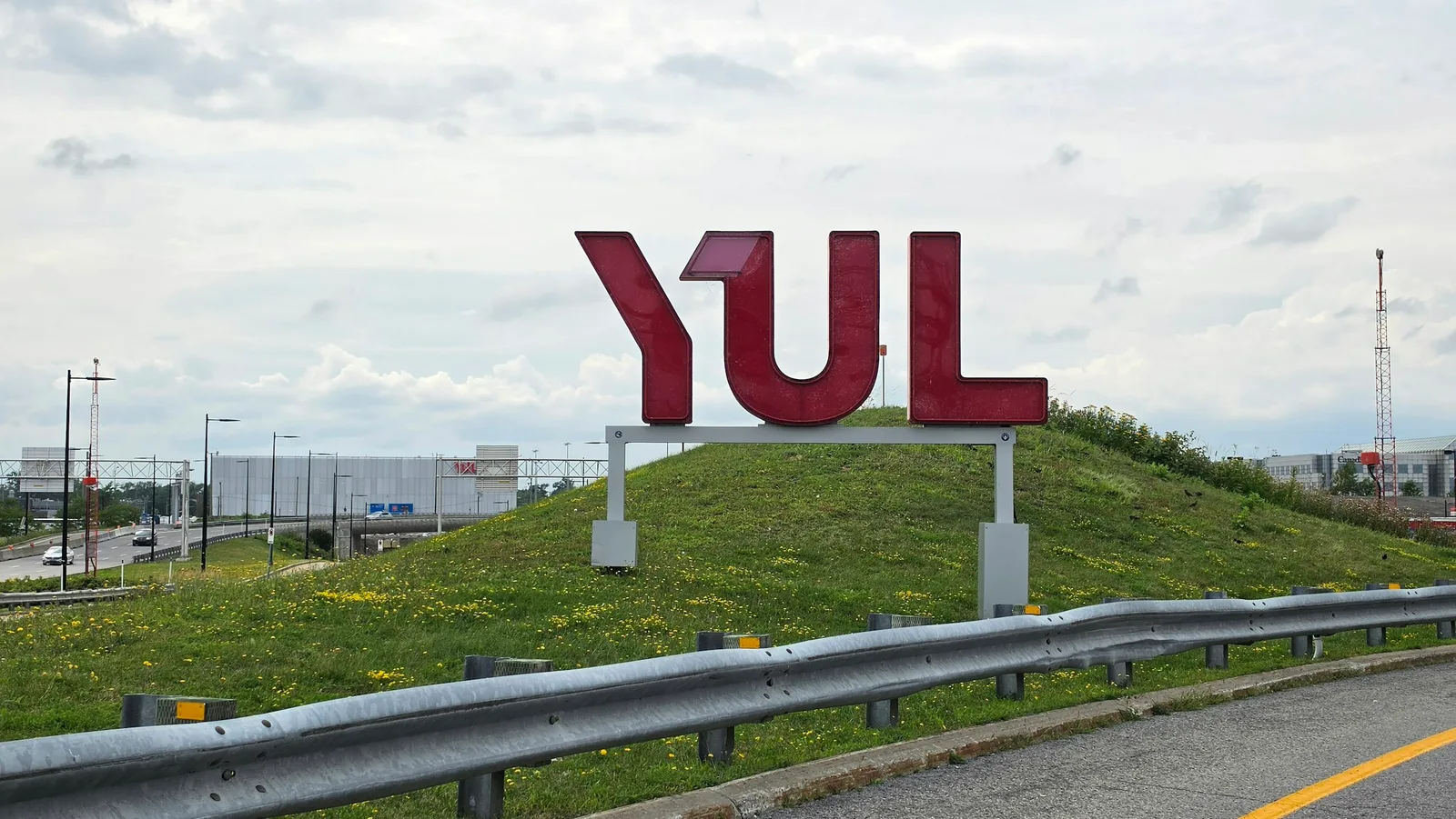 Grandes lettres rouges « YUL » sur une butte gazonnée près de l'aéroport Montréal-Trudeau, à Dorval
